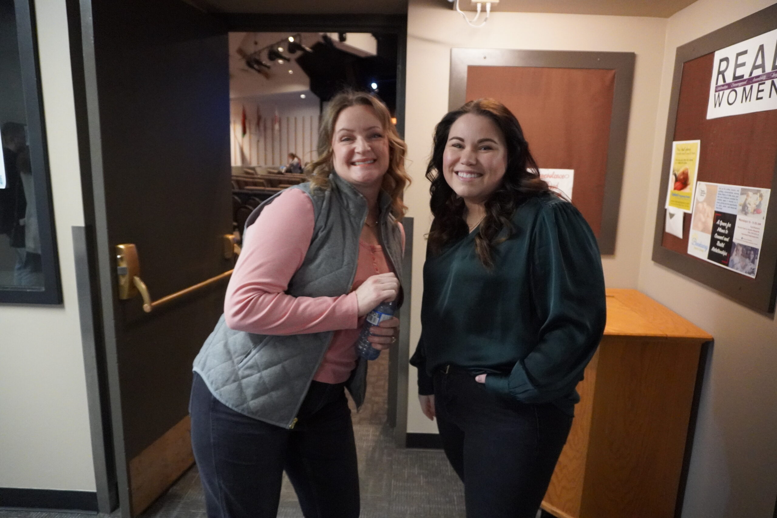person in red sweater holding babys hand